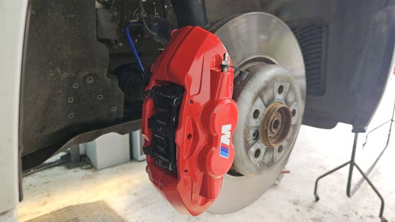 Red Brembo brake caliper fitted with titanium bleed valves