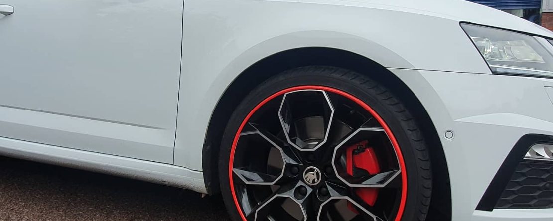 White car with red Alloygator alloy wheel protection trims