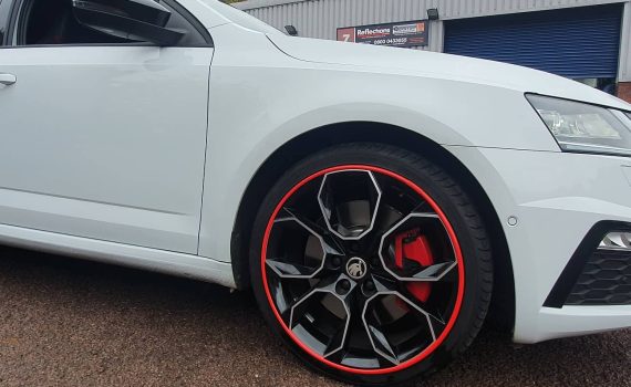 White car with red Alloygator alloy wheel protection trims
