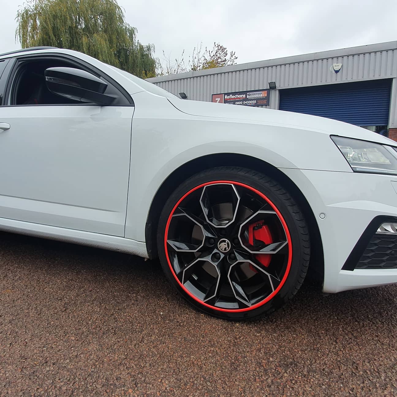 White car with red Alloygator alloy wheel protection trims